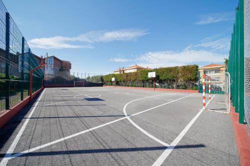 an empty tennis court with a net on it at 158A Triplex Rinconin con piscina in Gijón