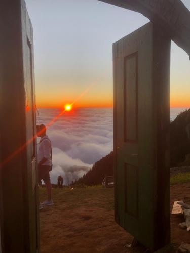 una persona de pie en una colina mirando la puesta de sol en Huser Bungalov, en Rize