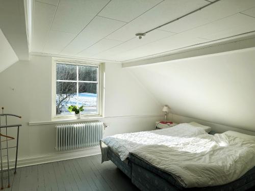 a white bedroom with a bed and a window at Nice holiday home in Balsta in Bålsta