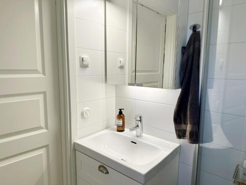 een witte badkamer met een wastafel en een spiegel bij Nice holiday home in Balsta in Bålsta