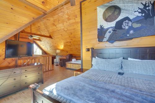 Schlafzimmer mit einem Bett und einem Flachbild-TV in der Unterkunft Central Sevierville Cabin with Hot Tub and Views! in Sevierville