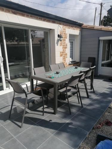 une table et des chaises assises sur une terrasse dans l'établissement L'INSTANT ZEN NATURISTE ONLY ADULTE, à Fresnay-en-Retz