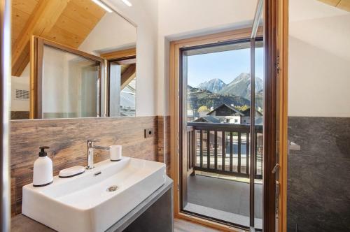 a bathroom with a sink and a window with a view at Olympic Chalet in Bormio