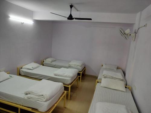 a group of four beds in a room at HOTEL PURI GREENS in Puri