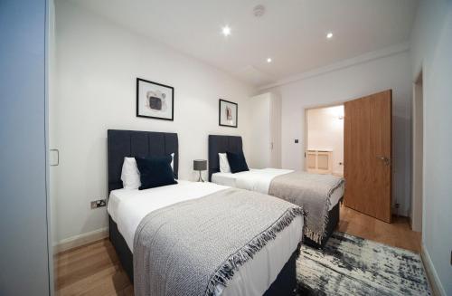 1 dormitorio con 2 camas y puerta en Spacious & Unique Flat in Hoxton - 2 bed, en Londres