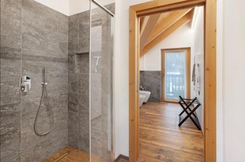 a bathroom with a shower with a glass door at Olympic Chalet in Bormio
