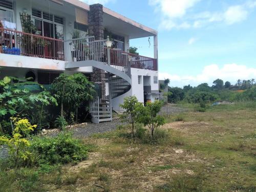 una casa con una escalera en el lateral de ella en Jolie studette dans un environnement arboré, en Les Abymes