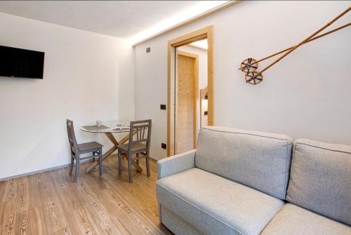 a living room with a couch and a table at Olympic Chalet in Bormio