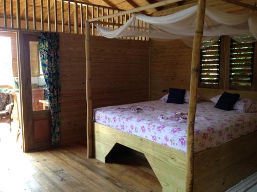 una camera con letto a baldacchino di Alibabas Cottage a Castara