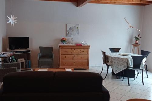 a living room with a table and chairs at La maison chez Doris et Francis in Thanvillé