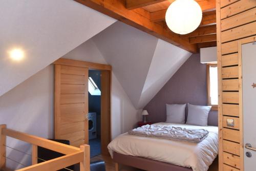 a bedroom with a bed in a attic at La maison chez Doris et Francis in Thanvillé