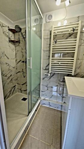 une douche avec une porte vitrée dans une salle de bain dans l'établissement Chalet Marseille hauteur, à Marseille
