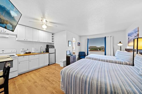 a hotel room with two beds and a kitchen at Surf & Sand Inn in Pacific City