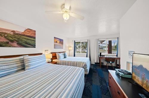 Habitación de hotel con 2 camas y ventilador de techo. en Surf & Sand Inn, en Pacific City