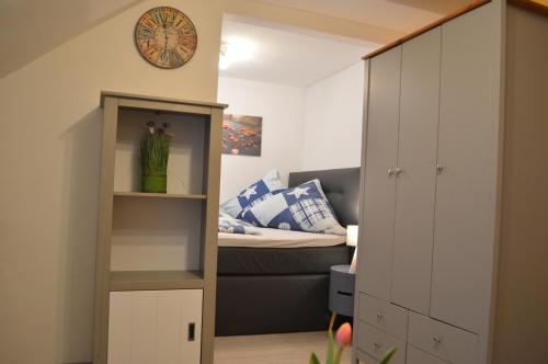a small bedroom with a bed and a cabinet at Ferienwohnung Meersburg 30m vom Bodensee in Meersburg