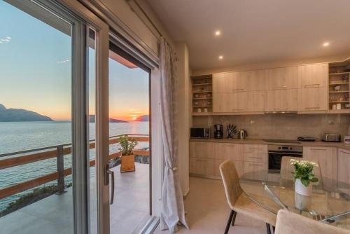 a kitchen with a table and a view of the ocean at Sunset Dreams Spyros in Kalymnos
