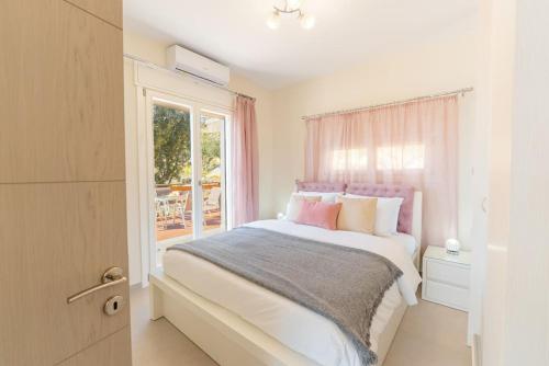 a bedroom with a large bed with a window at Sunset Dreams Spyros in Kalymnos