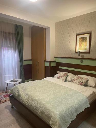 a bedroom with a large bed and a table at Hotel - Villa Lejla in Mostar