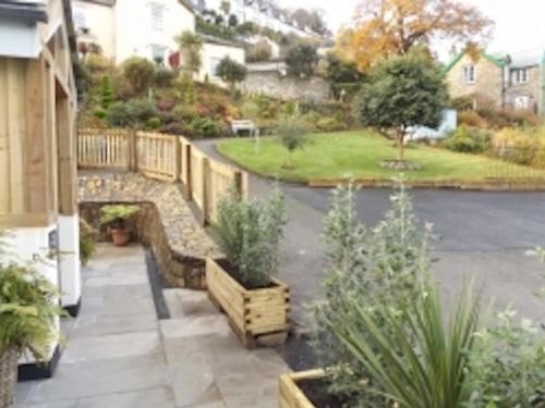 a garden with a wooden bridge and benches at Fern Cottage in Lynton