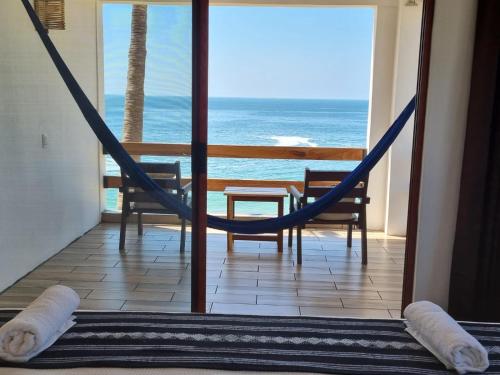 a hammock in a room with a view of the ocean at Posada Ziga Playa in Mazunte