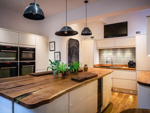 kuchnia z drewnianym blatem i lampkami w obiekcie Lonsdale Villa Retreat w mieście Penrith