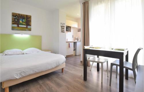a bedroom with a bed and a desk and a table at Lovely Apartment In quemauville With Heated Swimming Pool in Équemauville