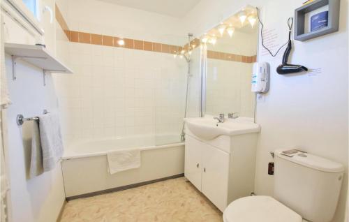 Baño blanco con aseo y lavamanos en Lovely Apartment In quemauville With Heated Swimming Pool, en Équemauville