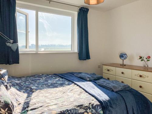 a bedroom with a bed and a window at Keel Annexe in Week Saint Mary