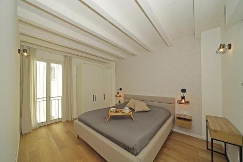 ein Schlafzimmer mit einem Bett und einem Tisch darauf in der Unterkunft La Cittadella P1-14 by Wonderful Italy in Manerba del Garda