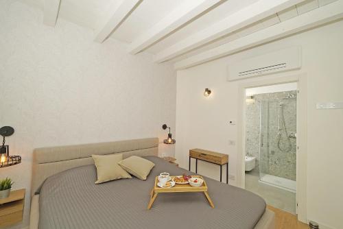ein Schlafzimmer mit einem Bett und einem Tablett darauf in der Unterkunft La Cittadella P1-14 by Wonderful Italy in Manerba del Garda