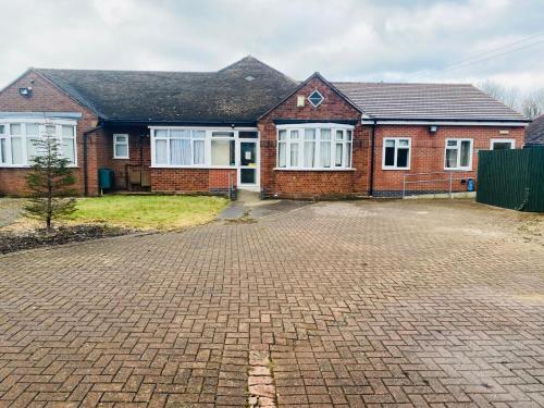 a brick house with a driveway in front of it at En-suites Rooms in Northampton in Moulton