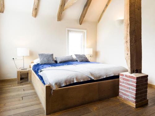 a bedroom with a large bed with blue sheets at Herberg de Kemper in Markelo