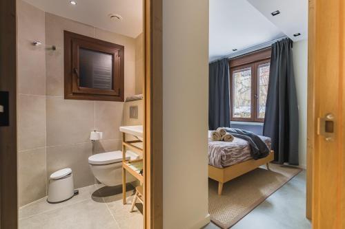 a bathroom with a toilet and a bed in a room at MIKKA CLOS in Soldeu