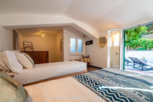2 Betten in einem Zimmer mit Fenster in der Unterkunft Casa Cristina by PortofinoVip in Portofino