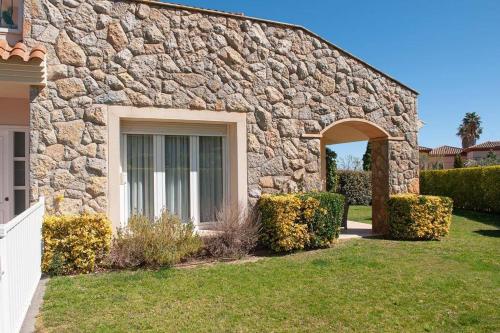un edificio de piedra con una ventana en un patio en Naturaleza, Playa, Montaña, Golf, en Bonmont Terres Noves