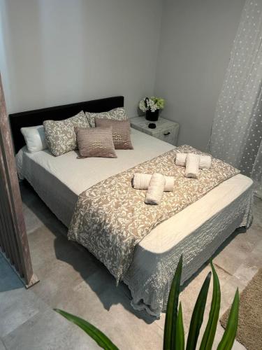 ein Schlafzimmer mit einem Bett mit Kissen und einer Pflanze in der Unterkunft MSK Rotonda Studio 1 in Thessaloniki