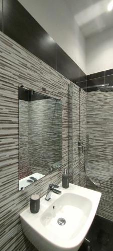 a bathroom with a sink and a mirror at VIGEVANO LA STAZIONE in Vigevano