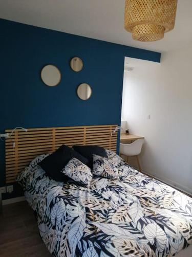 een slaapkamer met een bed met een blauwe muur bij Le Clos Duthu, Ideal curistes in Bagnères-de-Bigorre