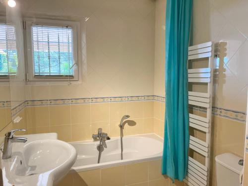 ein Badezimmer mit einem Waschbecken und einer Badewanne in der Unterkunft Villa Romuald in Sainte-Maxime