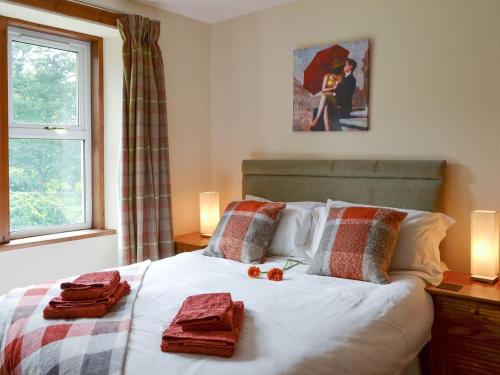 a bedroom with a bed with red towels on it at Nursery Cottage - Beaufort Estate in Kiltarlty