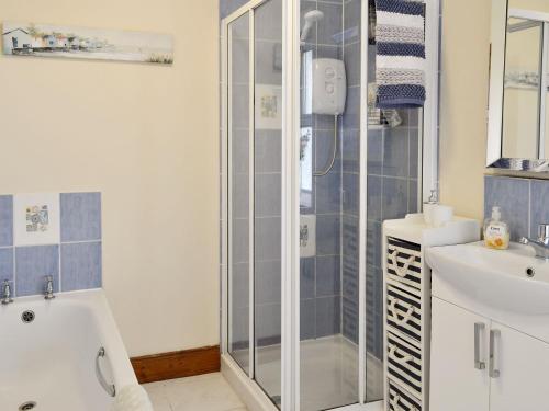a bathroom with a shower and a sink at Nursery Cottage - Beaufort Estate in Kiltarlty