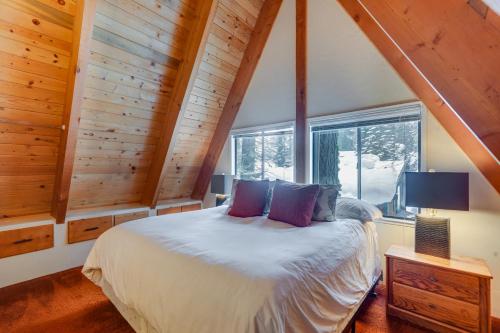 een slaapkamer met een bed en een groot raam bij Rustic Truckee Cabin with Donner Lake Views! in Truckee
