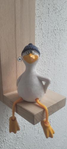 a toy penguin is sitting on a shelf at Apartmenthaus Westerkoog in Hedwigenkoog