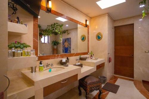 La salle de bains est pourvue de 2 lavabos et d'un grand miroir. dans l'établissement Preciosa casa La Tolina en Puebla, à Santa María Tonantzintla