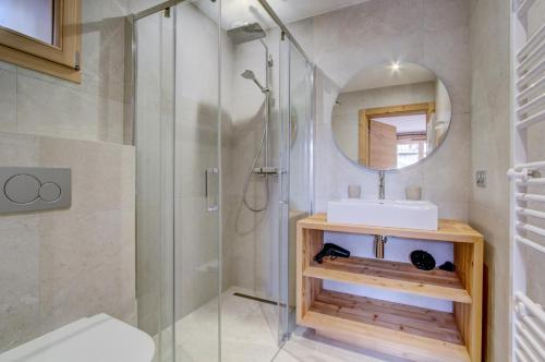a bathroom with a shower and a sink and a mirror at Chalet Tilly in Morzine