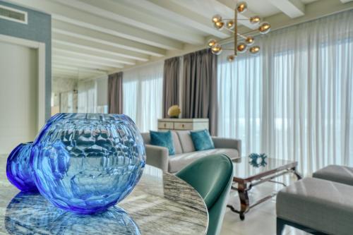a large blue glass vase sitting on a table in a living room at Palazzo della Scala Spa Hotel Suites & Apartments in Lazise
