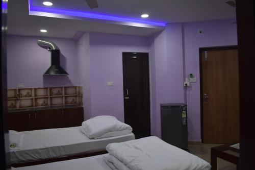a room with two beds and a blue light at HOTEL PURI GREENS in Puri