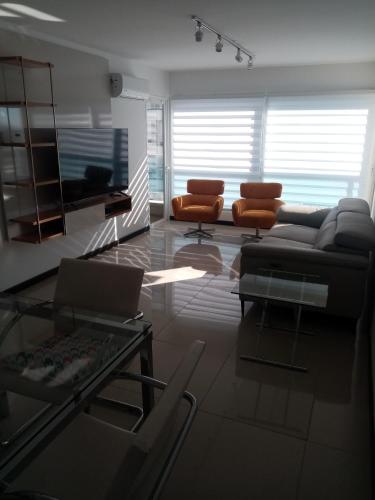 uma sala de estar com um sofá e uma mesa em Diamantis Apartamento de Lujo y Confort em Montevidéu