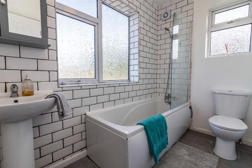 a bathroom with a tub and a toilet and a sink at Gedling Contractors Delight! in Nottingham