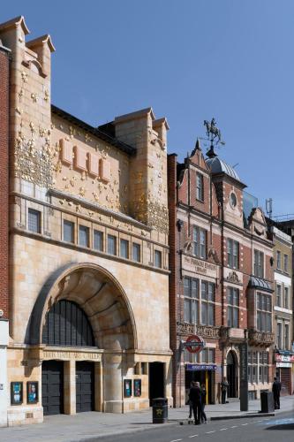 a large brick building with an archway in a city at The Grand M Showcase in London